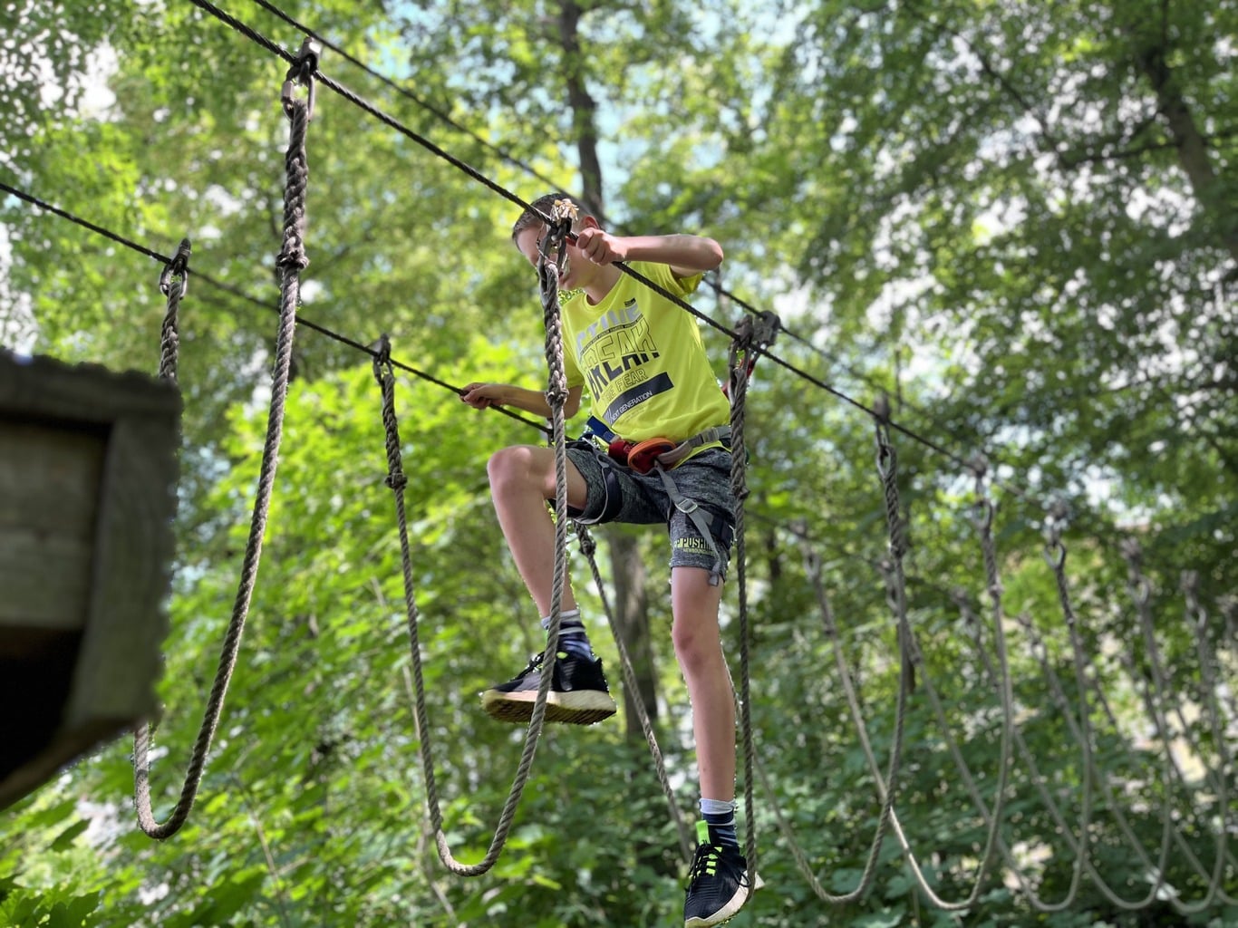 Kind beim Klettern auf Seilparcours - Familienspaß im Kletterwald